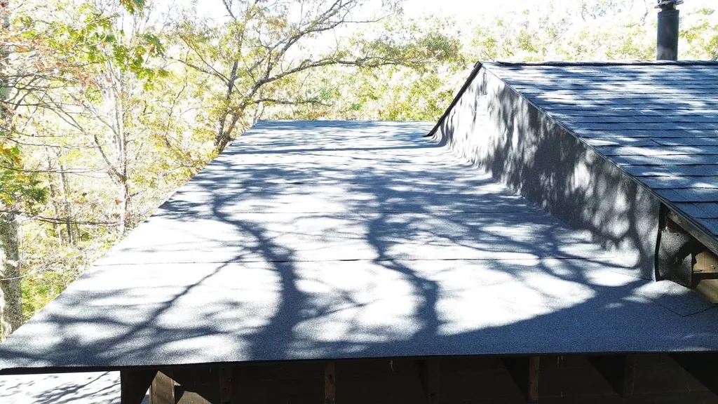 Low-Slope Roof Surface — St. Louis Maintenance Guide Article illustration of a low-slope roof membrane meeting an asphalt-shingle roof section