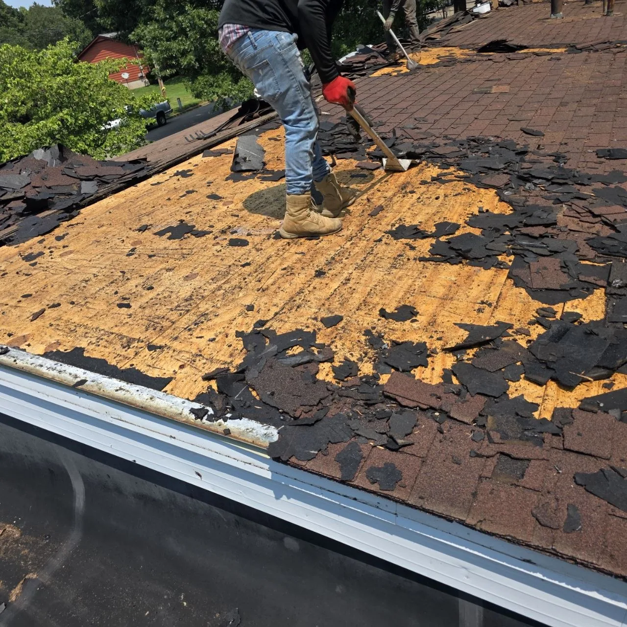 Roof Tear-Off and Decking Review — St. Louis Roof Program Roofing crew removing aged asphalt shingles to expose decking during a roof replacement