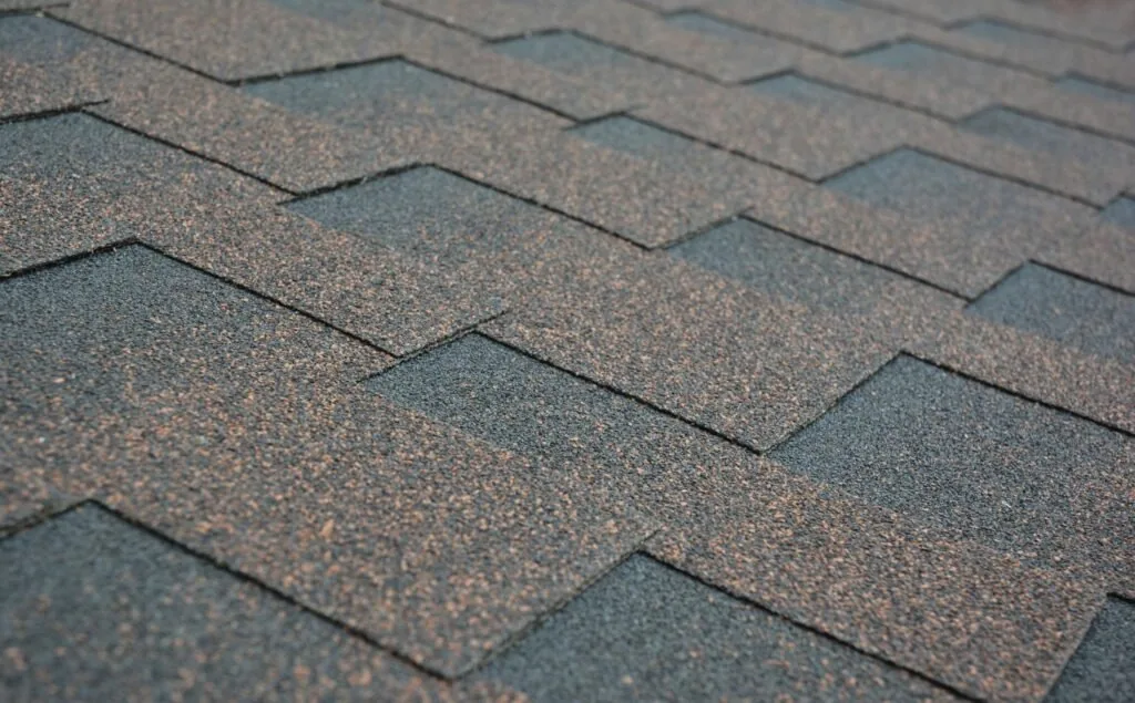Asphalt Shingles — Missouri Roof Shingle Guide Close view of gray-brown asphalt shingles on a residential roof