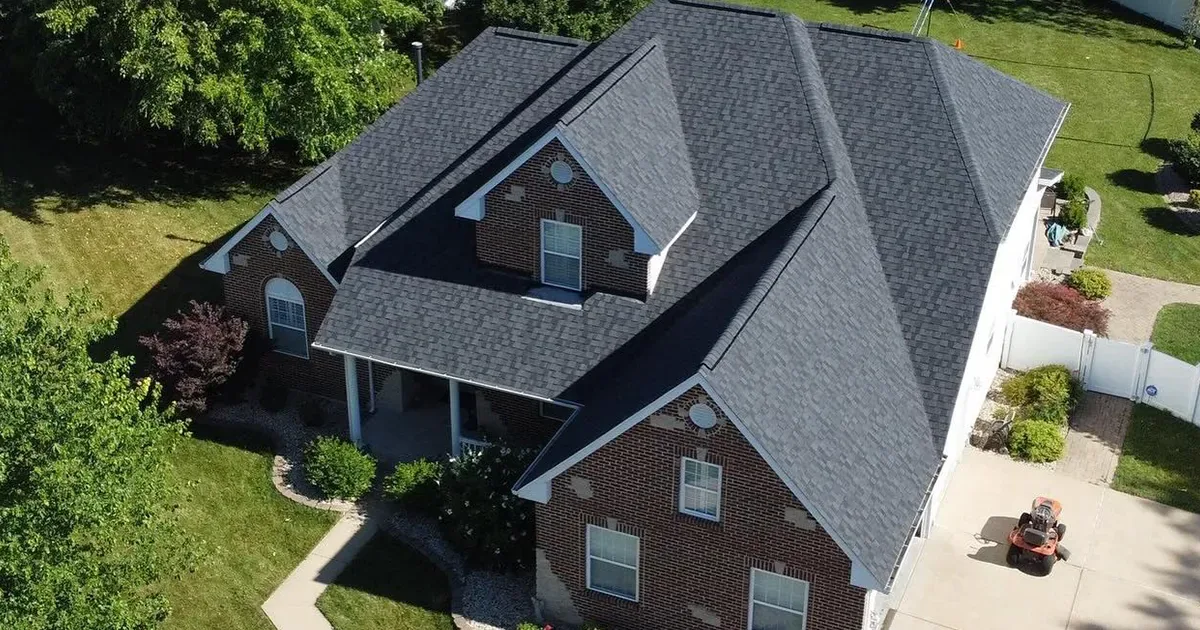 Multi-Plane Shingle Roof — Missouri Shingle Guide Aerial view of a brick home with a dark gray multi-plane shingle roof